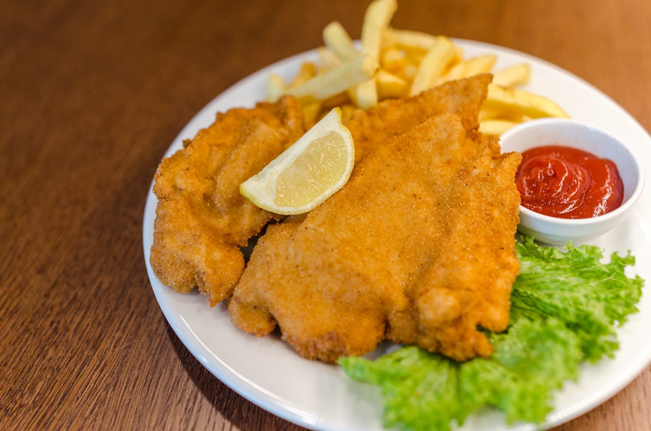 Schnitzel Pommes Ketchup Salat Zitronenscheibe Schnitzel Entstehungsgeschichte Wie entstand das Gericht